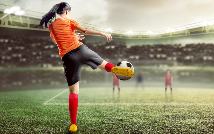Woman volleying a football/soccer ball